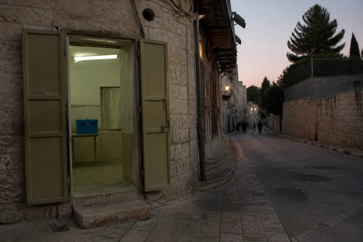 Eine ruhige Straße in Jerusalem mit dem Eingang eines Wahllokals in der Abenddämmerung